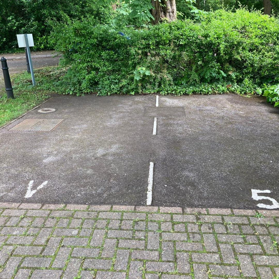 Moss-covered parking bays restored to clean tarmac – after
